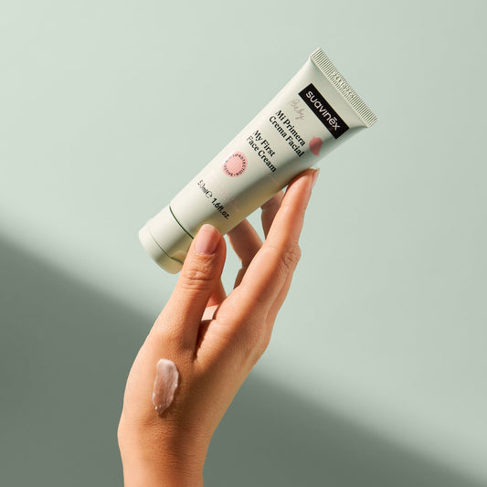 Hand holding a tube of suavinex my first face cream against a light gray background